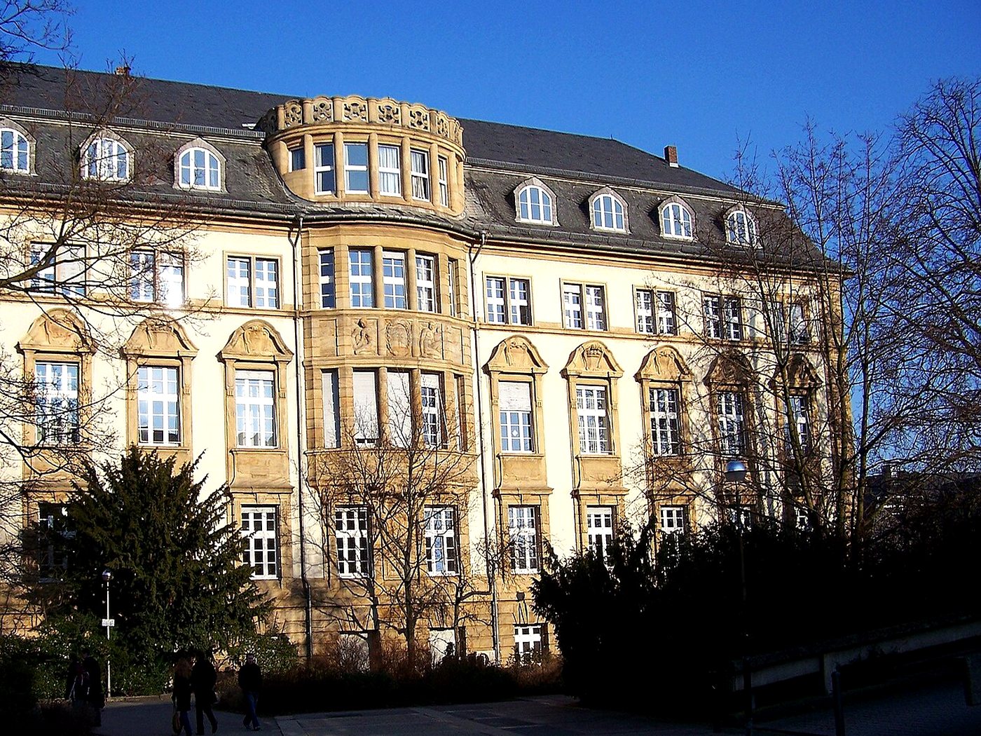 The west wing of the Altes Hauptgebäude at TU Darmstadt, Hochschulstrasse 1, under a clear sky.